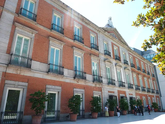 A close view of the brick façade of the Thyssen-Bornemisza Museum, with balconies and tall windows